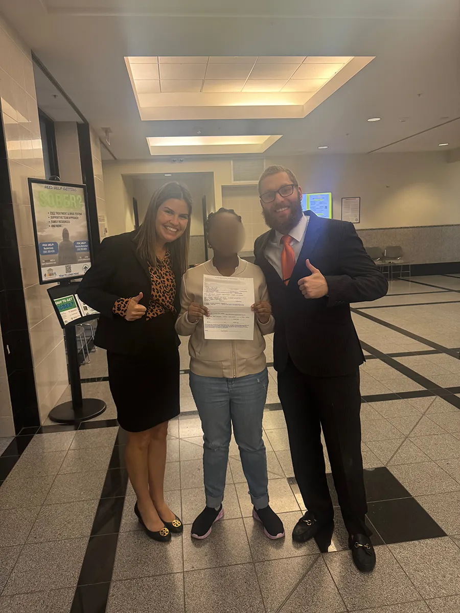 A team standing together with their client in the middle.